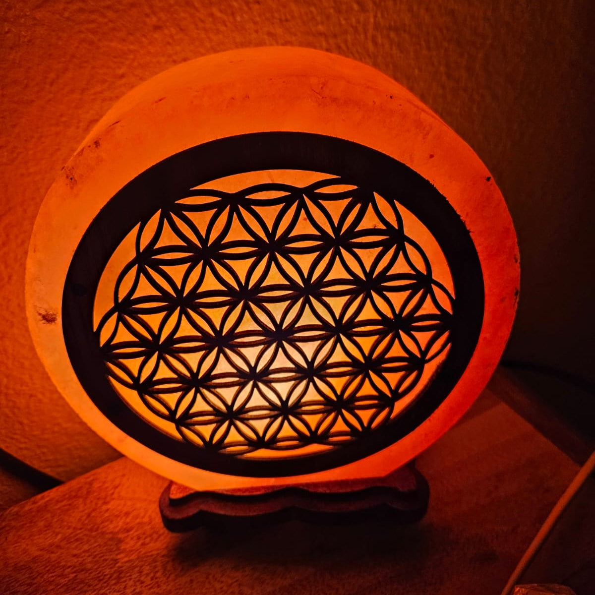 Salzkristalllampe mit einer Blume des Lebens aus Holz
